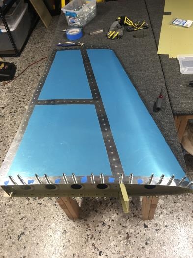 Only the root rivets remain. The blue taped holes remain unriveted for the fairing later on.