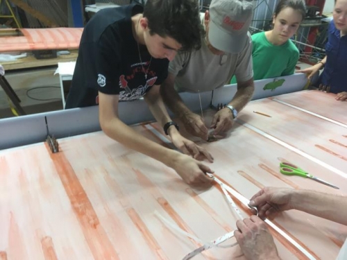 Laswon and Eric apply reinforcing tape to support the rib lacing