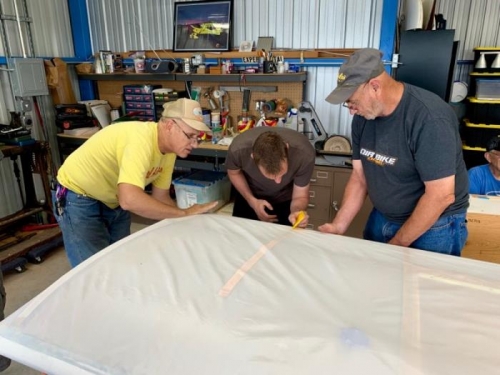 Eric, Bryan, and Steve work to glue on the leading edge fabric