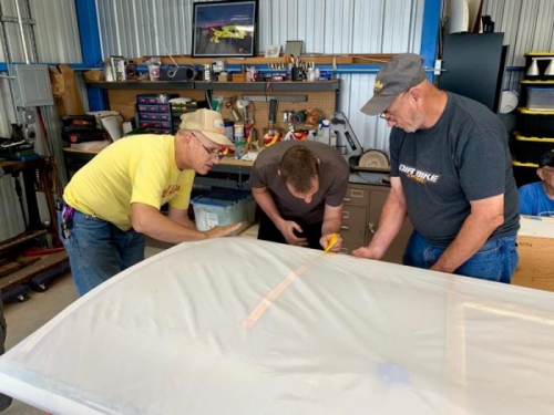 Eric, Bryan, and Steve work to glue on the leading edge fabric
