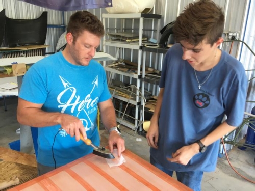 Lawson showing Eric E how to iron down the edges of the tapes with teflon