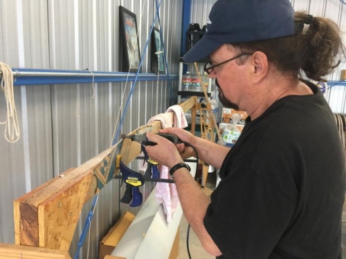 Michael uses a dremel to shape the plexiglas sides of the wing lockers to fit.