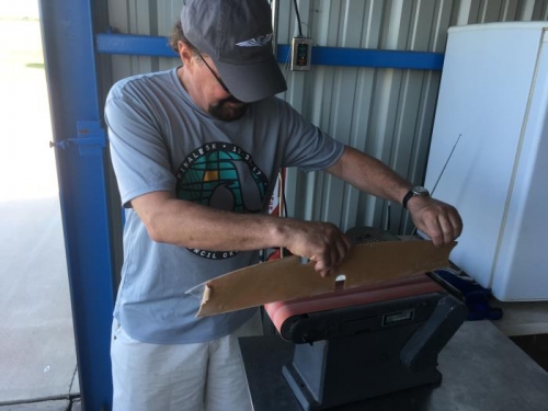 Michael using a belt sander to shape wing locker sides