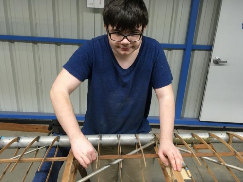 Carson sanding the ribs in preperation for fresh varnish.