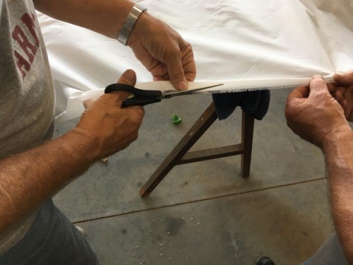 Steve and Eric carefully trimming frayed  factory edge of fabric