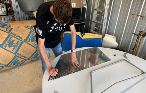 Laswon lays out a pattern for attaching the aluminum door skins