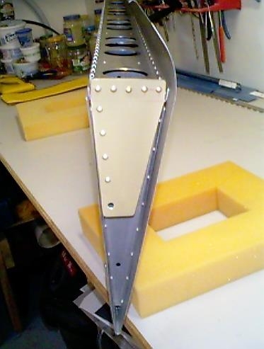 Right flap bracket riveted in place.