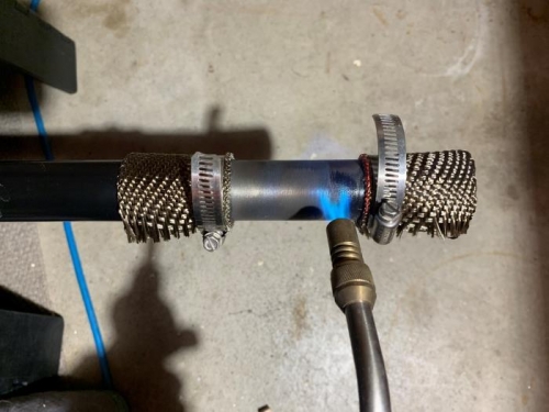 Clamped high-temp exhaust wrap to mask powder coating for torch and wire brush removal.
