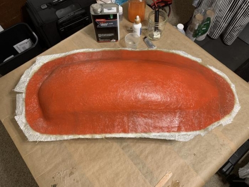 Orange tooling gelcoat applied, then fiberglass mat reinforcement apllied to the gelcoat.