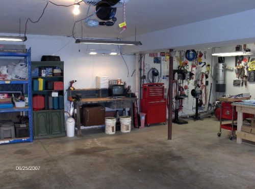 Relocated power tool storage, shelving and general work bench.