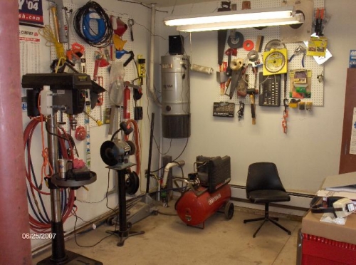 Corner of shop with drill press, grinder, compressor, etc.
