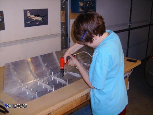 Tanner match drilling stiffeners to skins.
