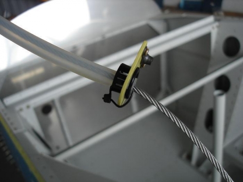 Plastic tube anchored to rudder cable support