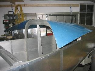 Fitting the top skin.  Van's had pop riveted two triangular pieces of sheet on the tangs extending forward from the overhead J c