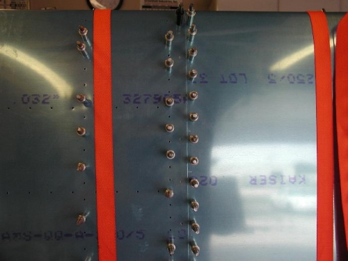 The ratchet strap helps hold the tank skin down onto the spar before drilling.