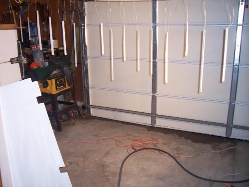 Stiffeners hanging off a rope strung between the garage door rails, skin in lower left of picture