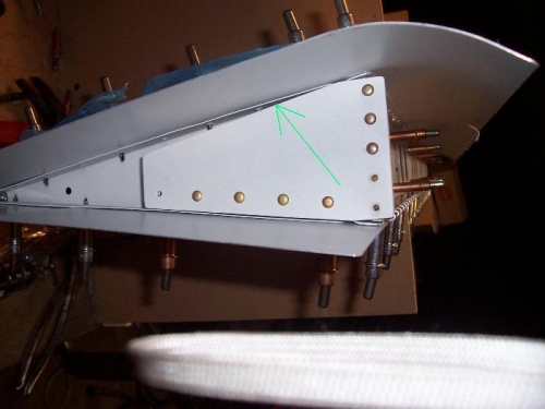 Arrow pointing to where top skin is clekoed to end rib...hard to buck the rivets behind the bracket