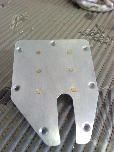 Inspection hole cover plate with servo bracket rivetted in place