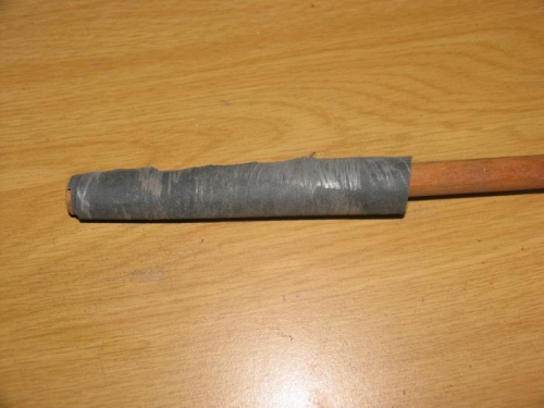 Sheet of sandpaper wrapped around a wooden dowel