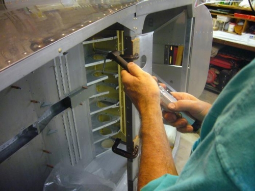Drilling out rivets on seat back brace slot angle.