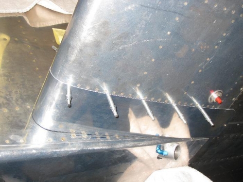 Fairing clecoed to bottom of wing skin flange on fuel tank.