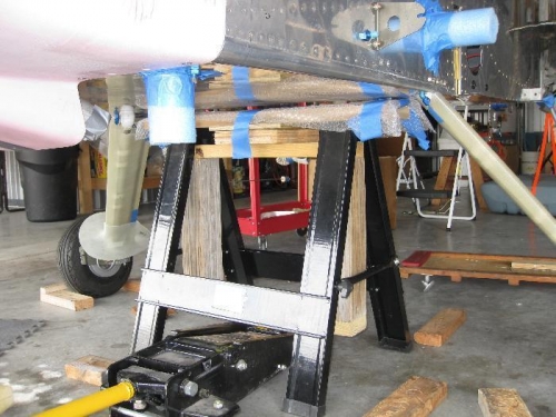 Floor jack under H-frame which is under the saw horse.