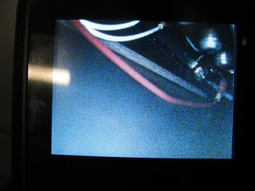 Shot of camera video screen, dowel is near main power connection lug which sticks out the farthest.