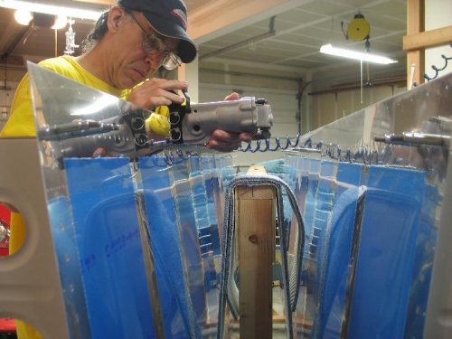 Pneumatic squeezer on most trailing end rivets.