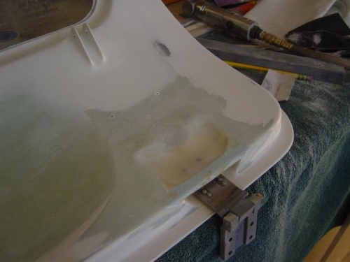 pilot door aft hinge cover fixed/repaired to allow for clearance w/ strut bracket