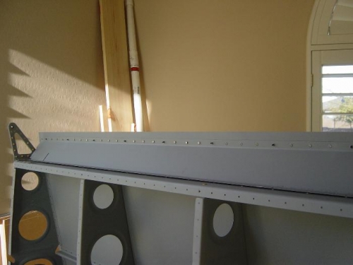 Riveting aileron gap seal to top skin