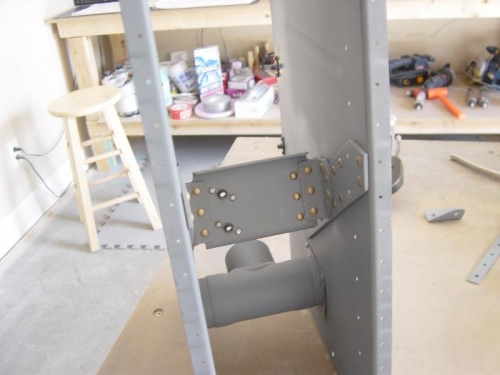 Flap actuator arrach bracket riveted in place