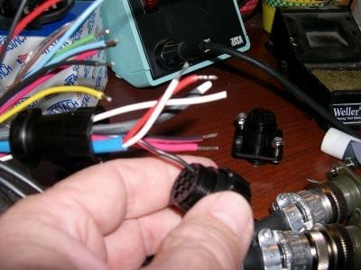 Inserting pin connectors into plug shell