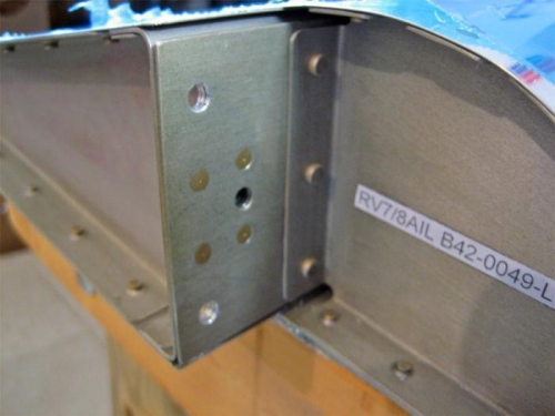 The attach holes in the aileron spar must be drilled through, enlarged and deburred.