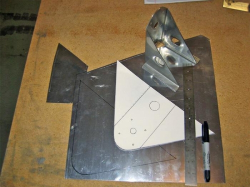 Steel prototype, cardboard pattern, and aluminum stock marked for cutting.