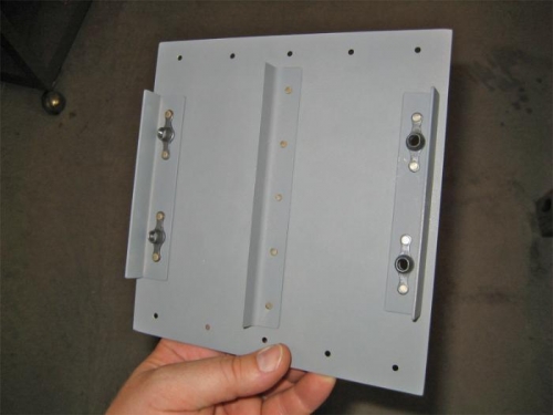 The backside of the strobe power-pack mounting plate, showing the platenuts and stiffeners.