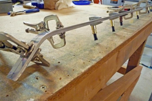 Canopy rail is bent, drilled, and clecoed to the support bar.