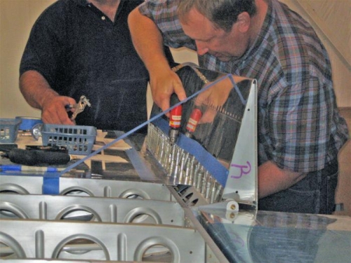 Drilling the flap hinge to the wing. The blue tape near the drill protects the skin from the chuck.