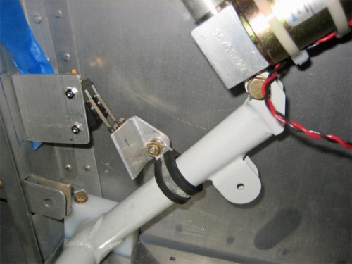 The striker plate on the flap arm closes the two microswitches mounted to the attach angle at left.