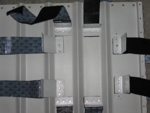 First aid and survival kit retaining brackets riveted to the right seat backrest aft side