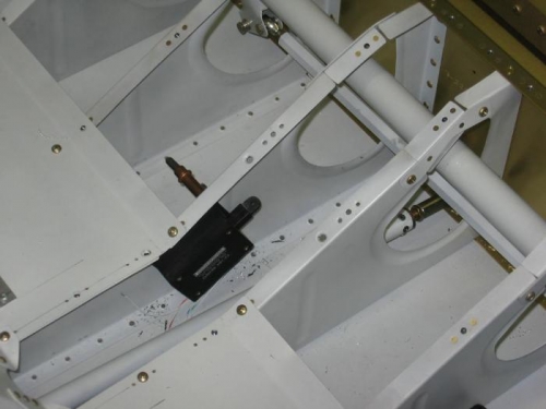 Aileron trim actuator drilled to the cabin floor rib