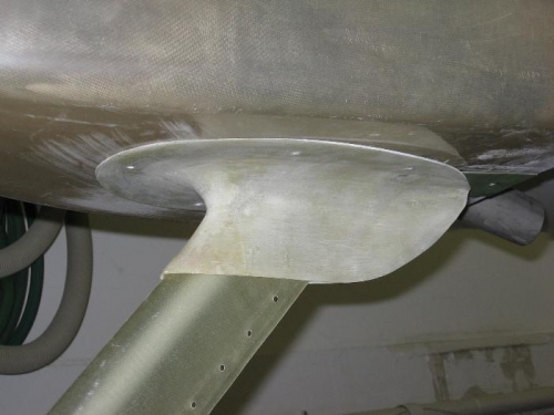 Nose landing gear leg upper intersection fairing drilled to the bottom of the engine cowling