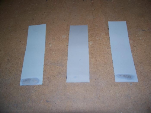 Paint test strips with solvent damage to the bottoms