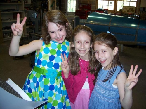 Nieces, Hannah, Martina and Brooke, flash victory signs after dimpling and signing the fuselage skin