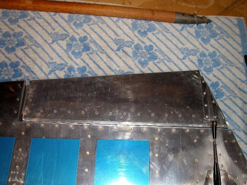 Trim tab riveted in place