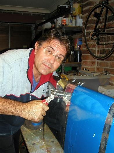 One hand inside to hold the lens in place and drill then cleco