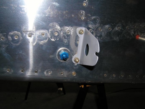 Bolted on both fuel tank attach brackets