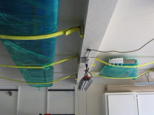 Empennage pieces suspended from ceiling with old firehose.