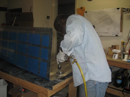 Riveting the fuel cap fitting.