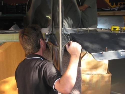 Dean helping pull through rudder cables.