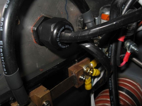 Cable harnesses through firewall gland.